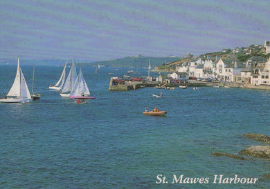 Sailing boats in St. Mawes Harbour with buildings on a hillside.