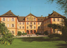 Load image into Gallery viewer, Large building with a garden in front on a clear day
