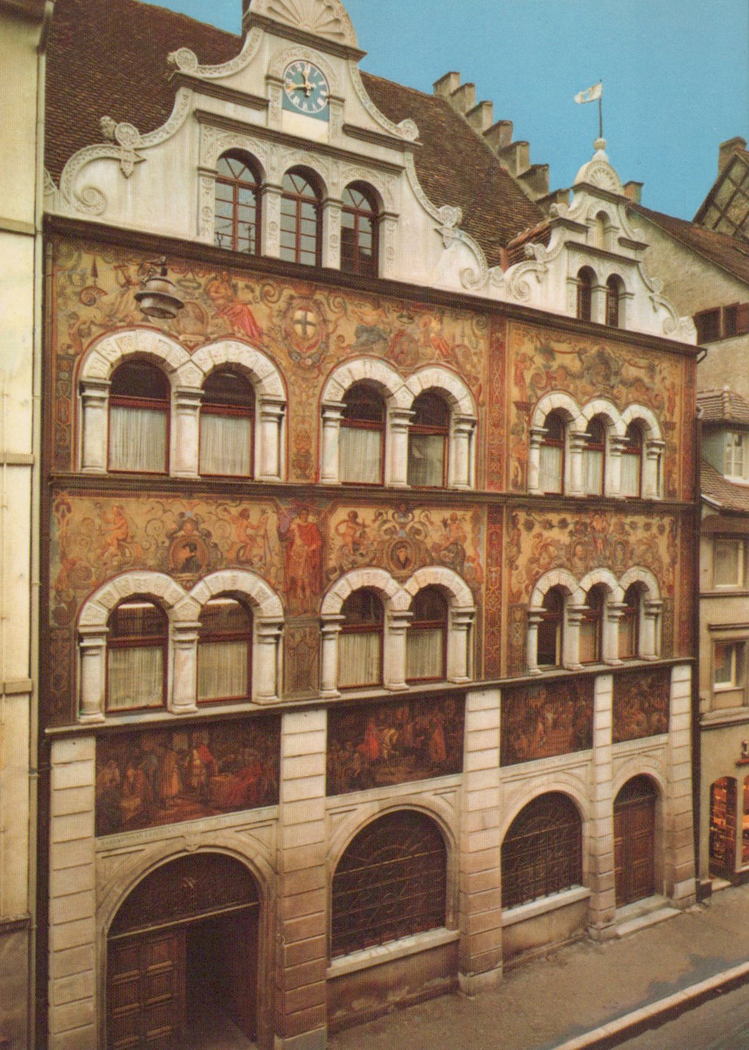 Decorative building facade with artistic murals on a street corner.