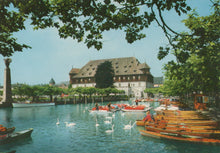 Load image into Gallery viewer, Historic building by a lake with boats and swans on a sunny day
