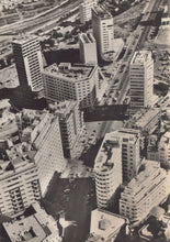 Load image into Gallery viewer, Aerial view of a cityscape with modern buildings
