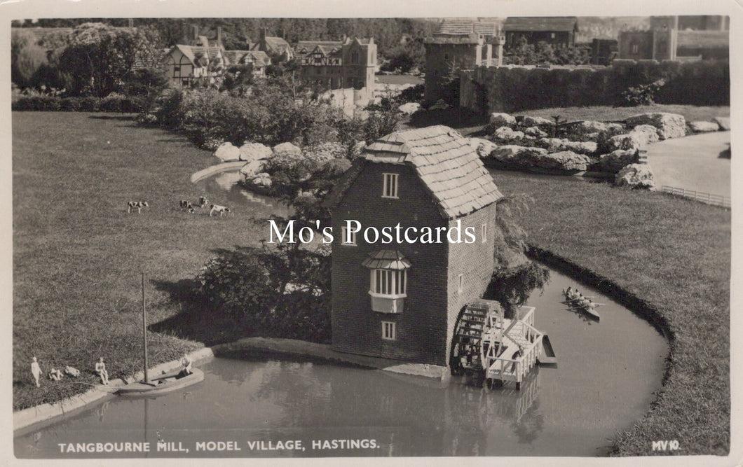 Model village scene with a mill and people around a pond, labeled 'Mo's Postcards'.