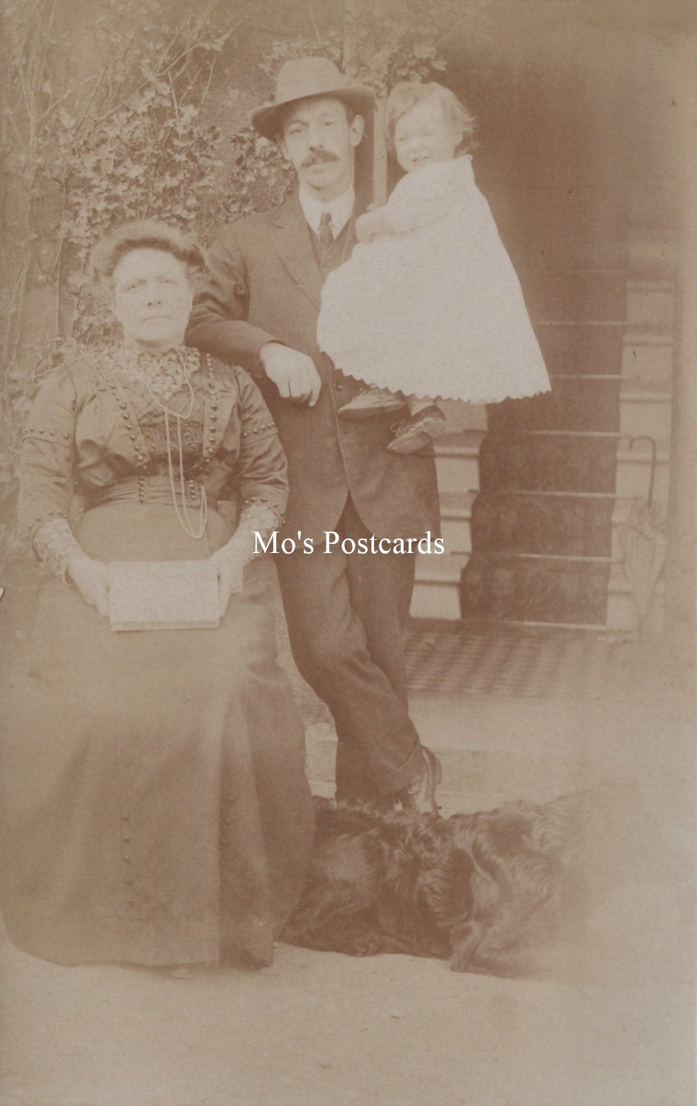 Vintage sepia-toned photograph of a family posing outdoors.