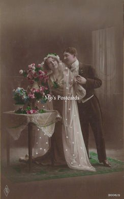 Vintage-style postcard of a couple with flowers and a tablecloth.