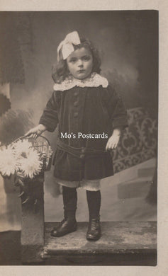 Vintage photograph of a young girl in formal attire with a decorative bow, labeled 'Mo's Postcards'.