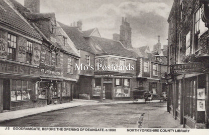 Vintage black and white photo of a street scene with shops and pedestrians 