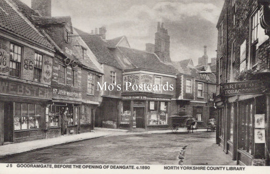 Vintage black and white photo of a street scene with shops and pedestrians 