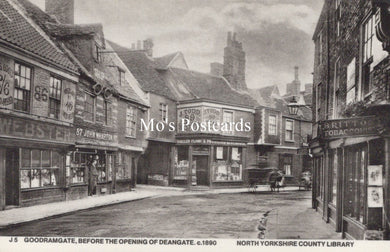 Vintage black and white photo of a street scene with shops and pedestrians 
