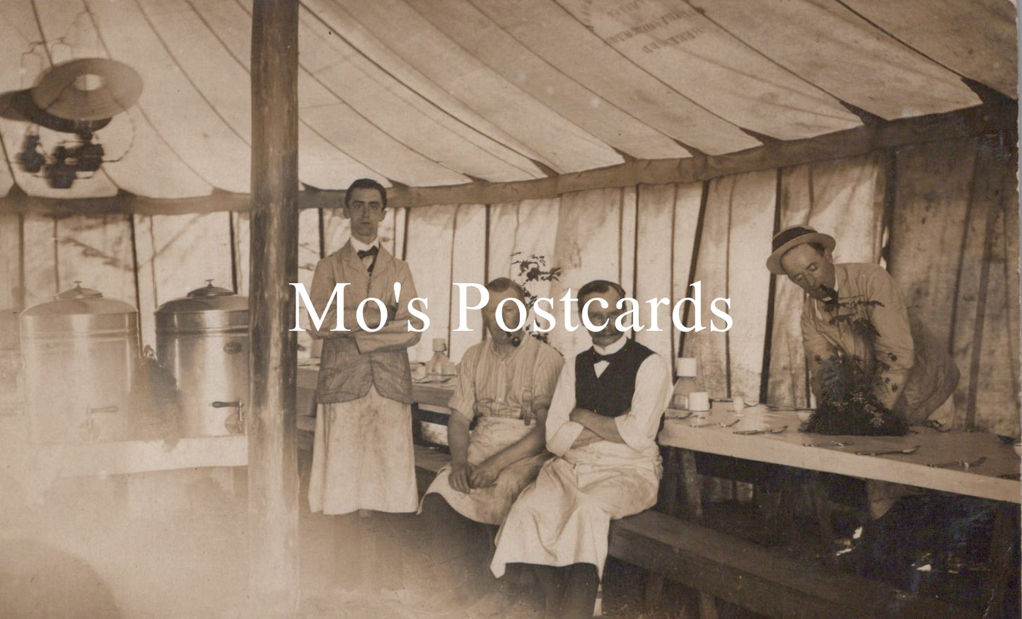 Vintage black and white photo of men inside a tent