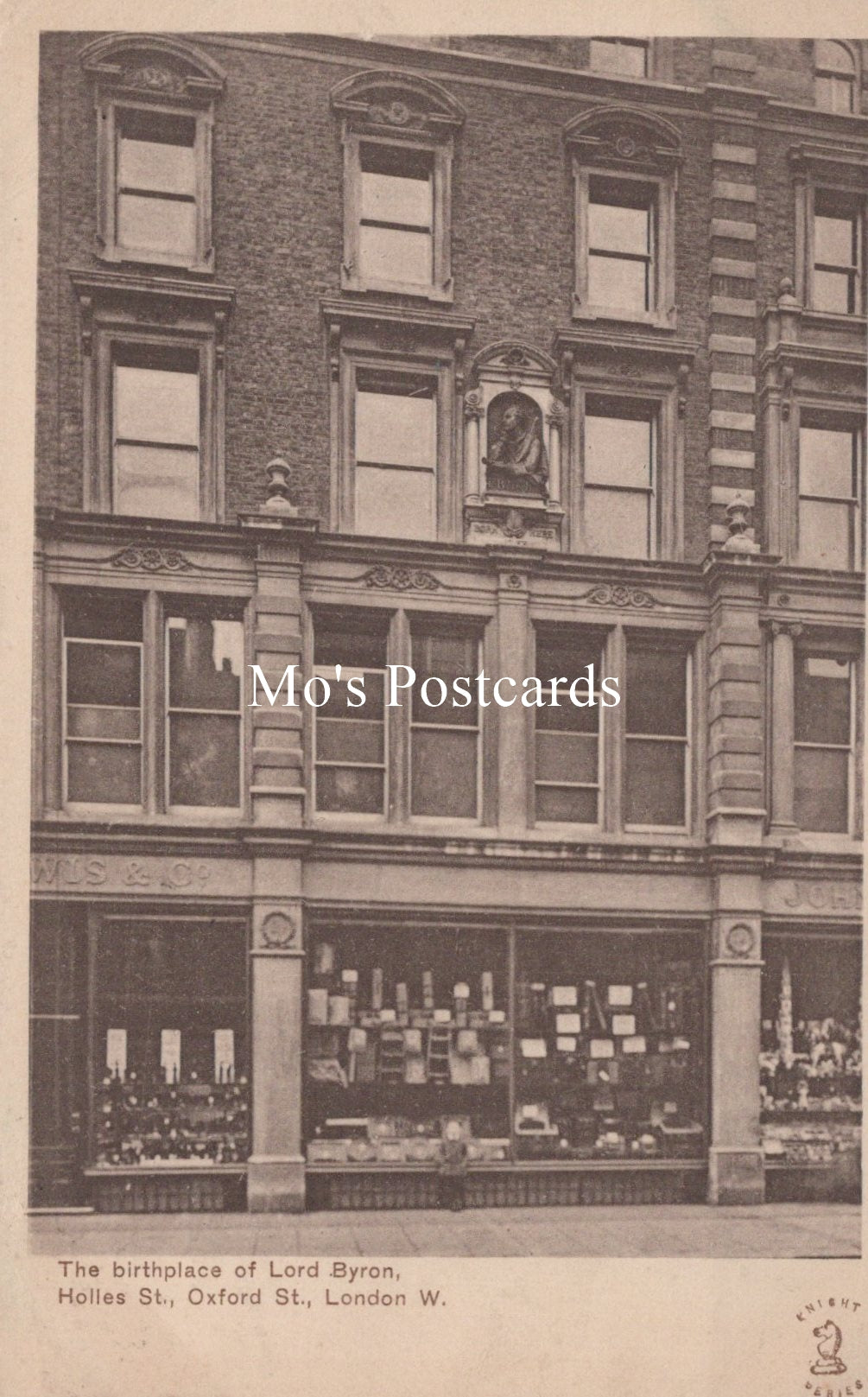 Vintage black and white postcard of a building facade with a store front, labeled 'Mo's Postcards'.
