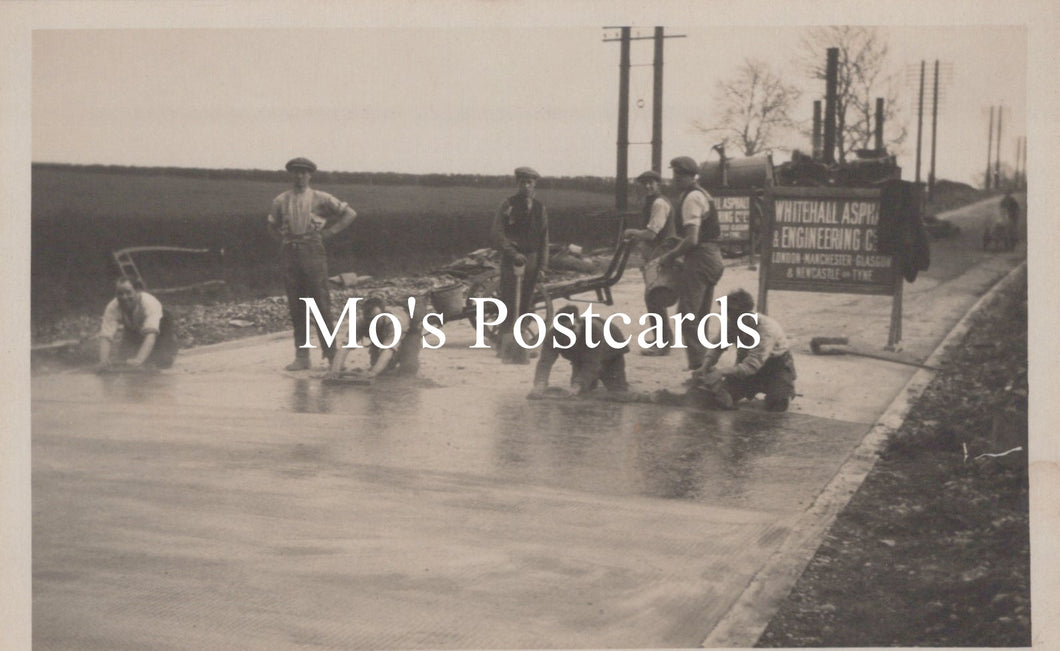 Vintage black and white photo postcard of people working on a road  