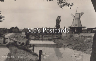 Vintage black and white postcard of a windmill by a canal  