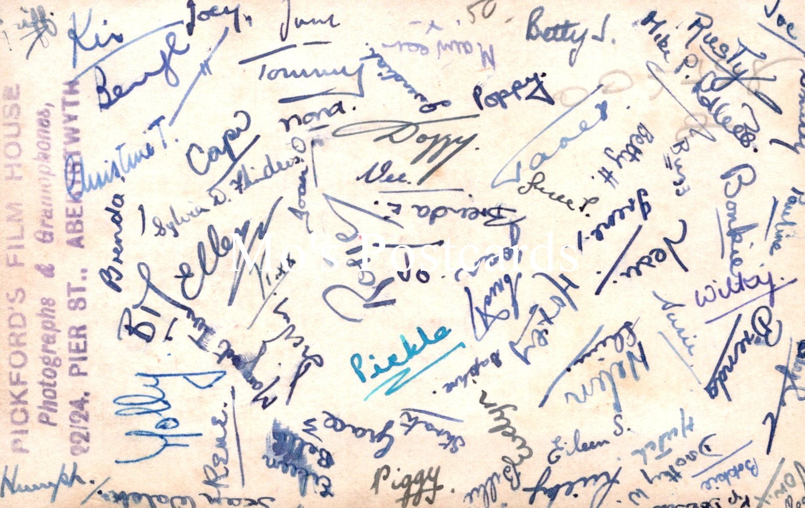 Sheet of paper with various handwritten signatures in blue ink on a beige background.