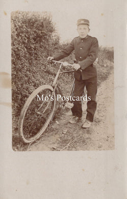 Vintage photograph of post delivery boy with a bicycle on a path with foliage.