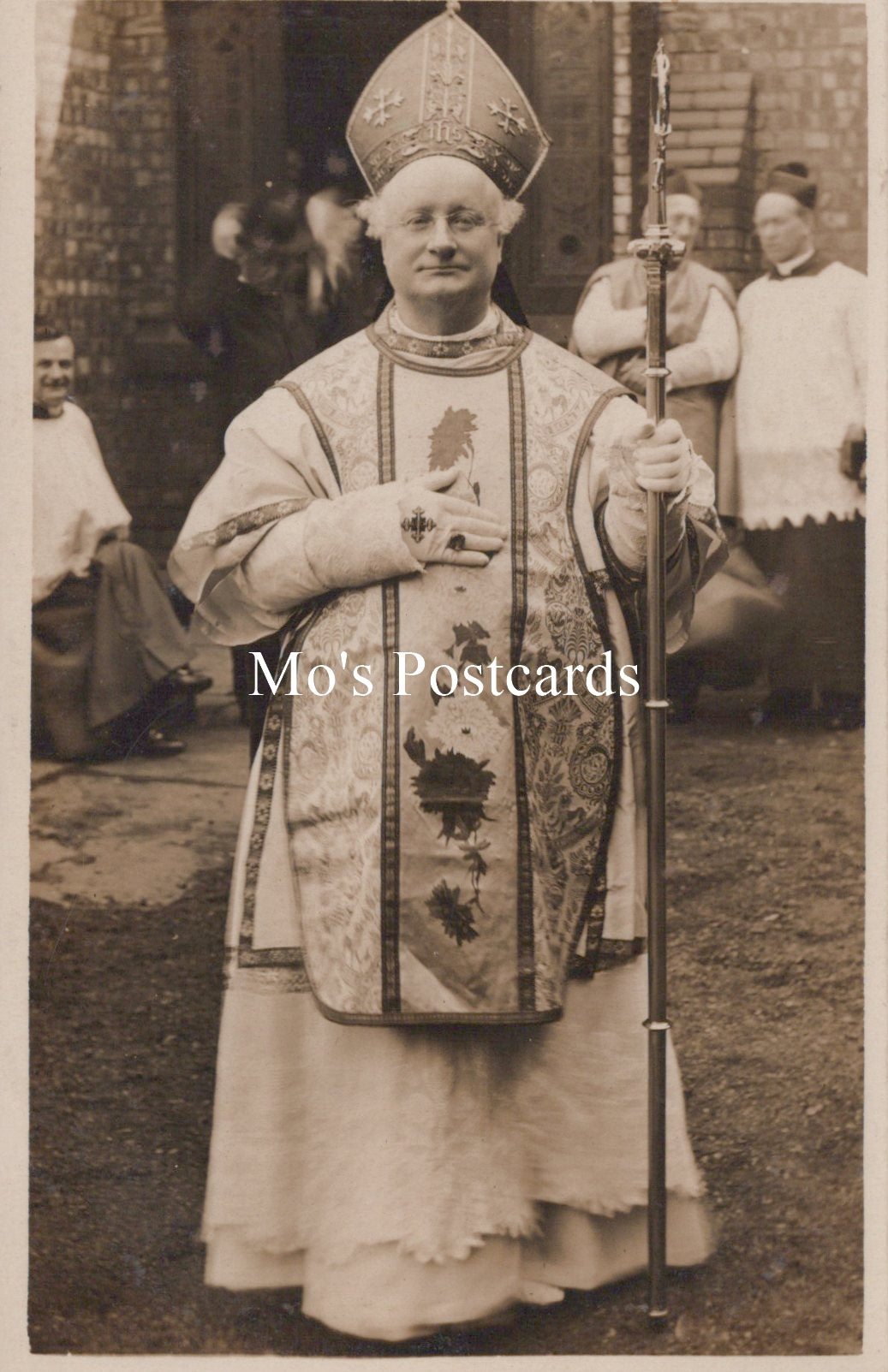 Vintage postcard of a person in religious attire with a staff, standing outdoors.