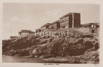 Vintage black and white postcard of a coastal scene with buildings on a cliff.