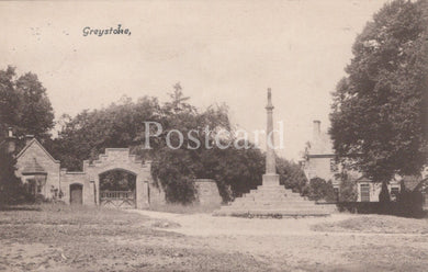 Vintage black and white postcard of a gatehouse and cross in a park-like setting with trees.