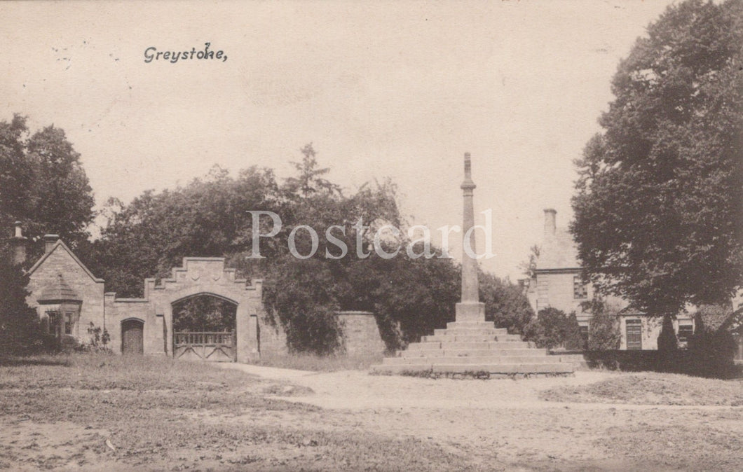 Vintage black and white postcard of a gatehouse and cross in a park-like setting with trees.