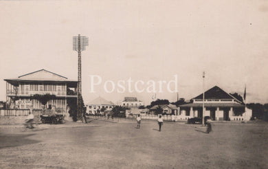 Vintage black and white photo of a sports field with buildings and people