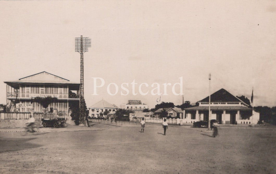 Vintage black and white photo of a sports field with buildings and people