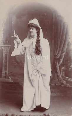 Vintage photograph of a woman in a white dress with a veil, holding a cigarette, on a postcard.