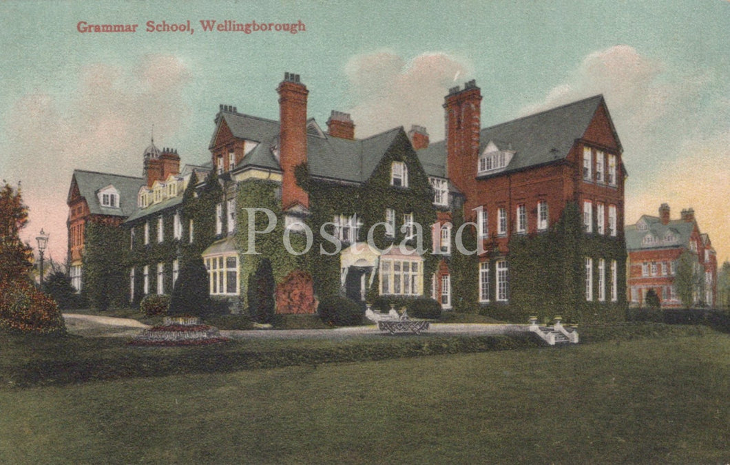 Colorized postcard of a large brick building with 'Grammar School, Wellingborough' text.