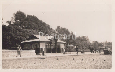 Vintage black and white photo of a building with people around, likely from a postcard.