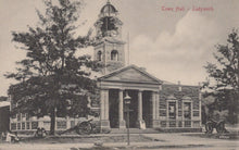 Load image into Gallery viewer, Vintage black and white photograph of a town hall building with clock tower and cannons in front.
