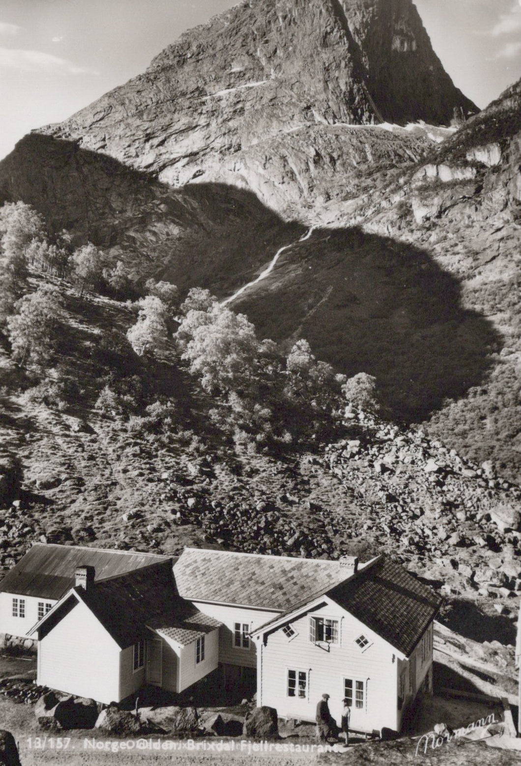 Vintage black and white photo of houses nestled in a mountainous landscape