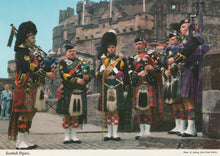 Load image into Gallery viewer, Group of Scottish pipers in traditional dress standing in front of a castle.
