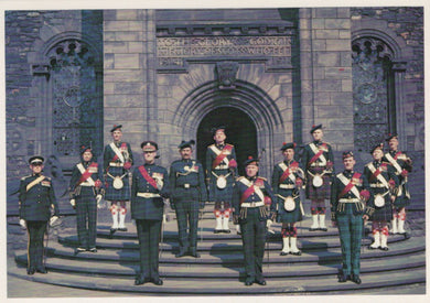 Formal group of men in uniform standing in front of a large stone building.
