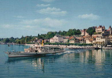 Vintage steamboat on a lake with a scenic town and castle in the background