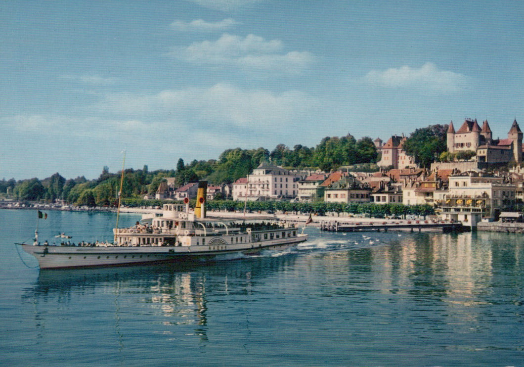 Vintage steamboat on a lake with a scenic town and castle in the background