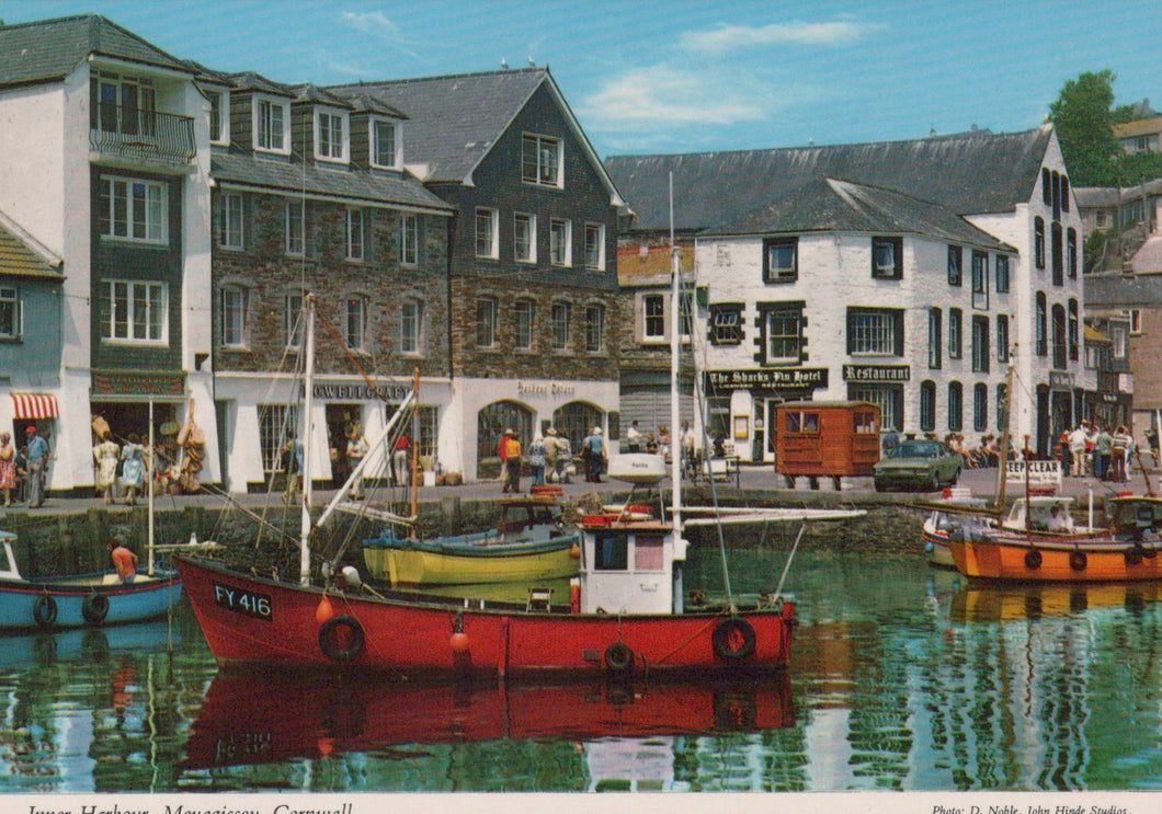 Harbor scene with boats and buildings in a small town setting.