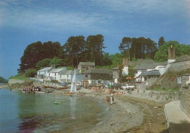 Coastal village with houses, boats, and people near a body of water.