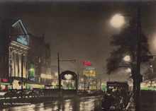 Load image into Gallery viewer, City street at night with illuminated signs and buildings.
