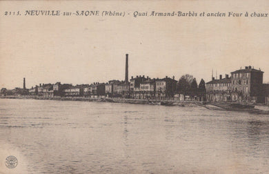Vintage black and white photo of a waterfront scene with buildings and a river.