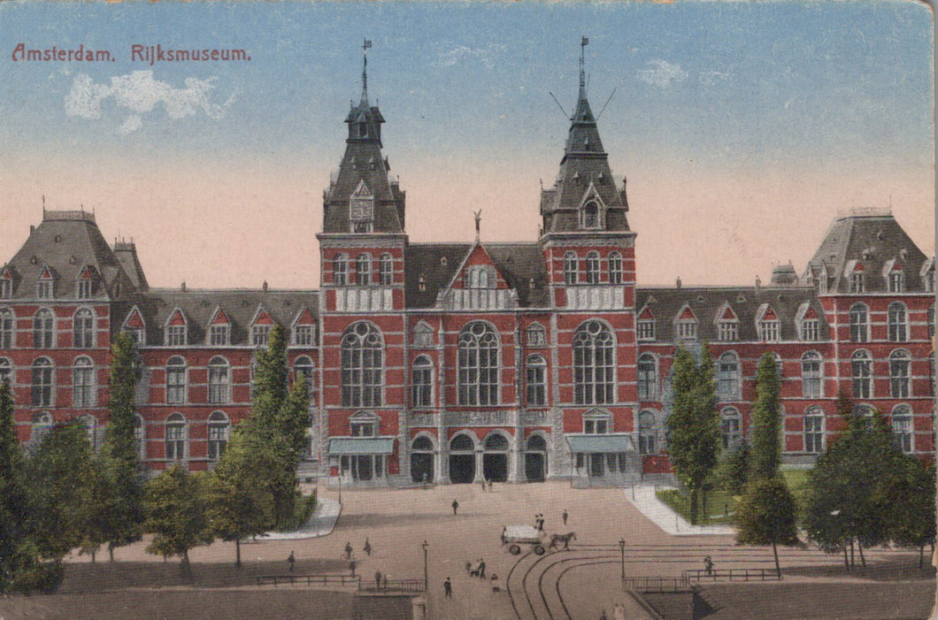 Vintage postcard of the Rijksmuseum in Amsterdam with a red brick building and green trees.