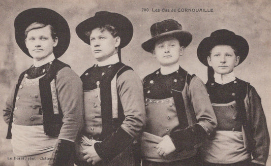 Four men in uniform with hats, standing side by side on a vintage photo.