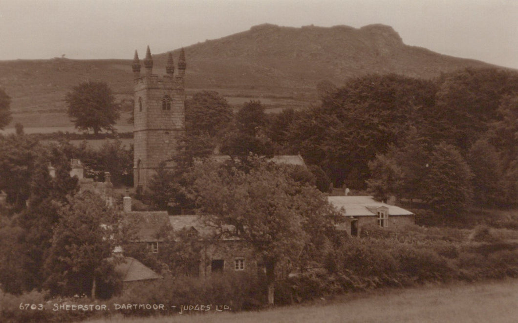 Vintage sepia-toned photograph of a village with a church and surrounding landscape.