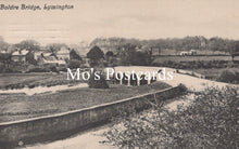 Load image into Gallery viewer, Vintage black and white photo of a bridge over a river with buildings in the background 
