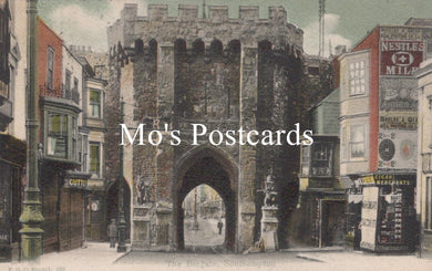 Vintage street scene with a large stone archway and colorful signs 