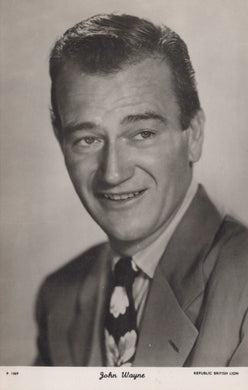 Black and white portrait of a smiling man in a suit with a Republic British Lion logo.