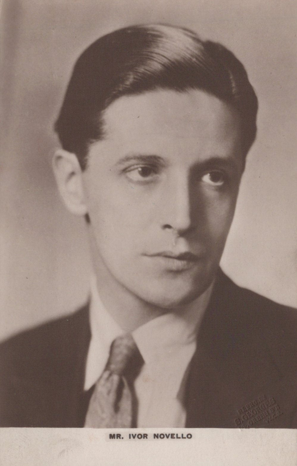 Vintage black and white portrait of a man wearing a suit and tie.