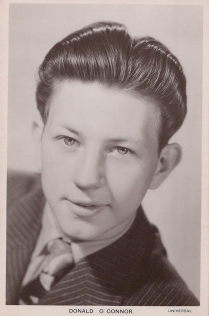Vintage black and white portrait of a man with styled hair, wearing a suit.