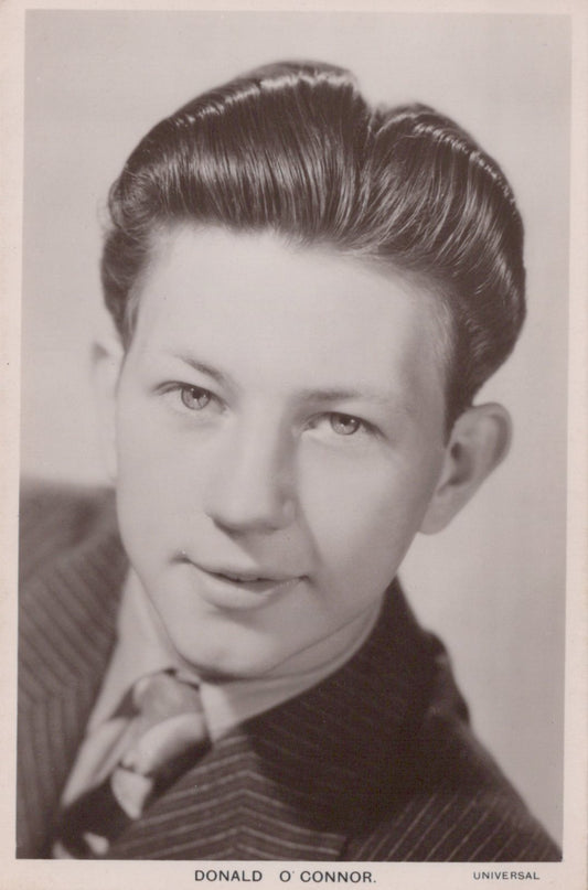 Vintage black and white portrait of a man with styled hair, wearing a suit.