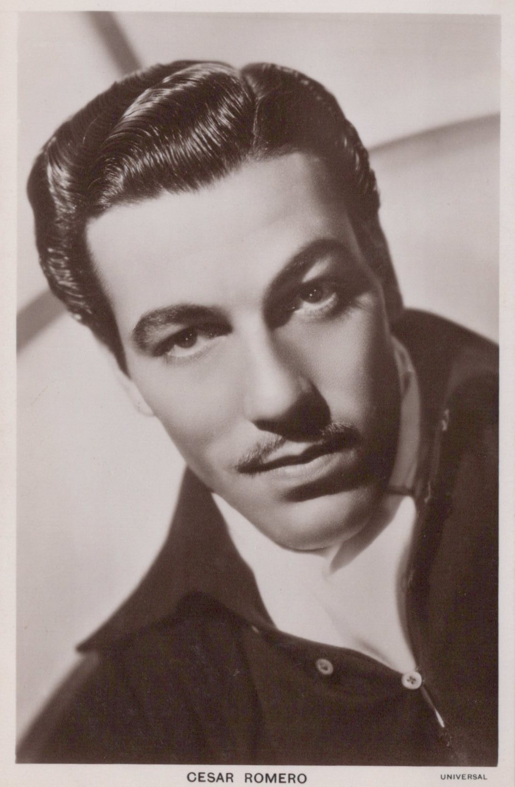 Black and white portrait of Cesar Romero with a blurred background