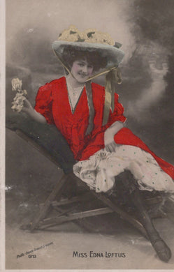 Woman in a red dress and large hat sitting on a bench, with 'Miss Eona Loftus' text.