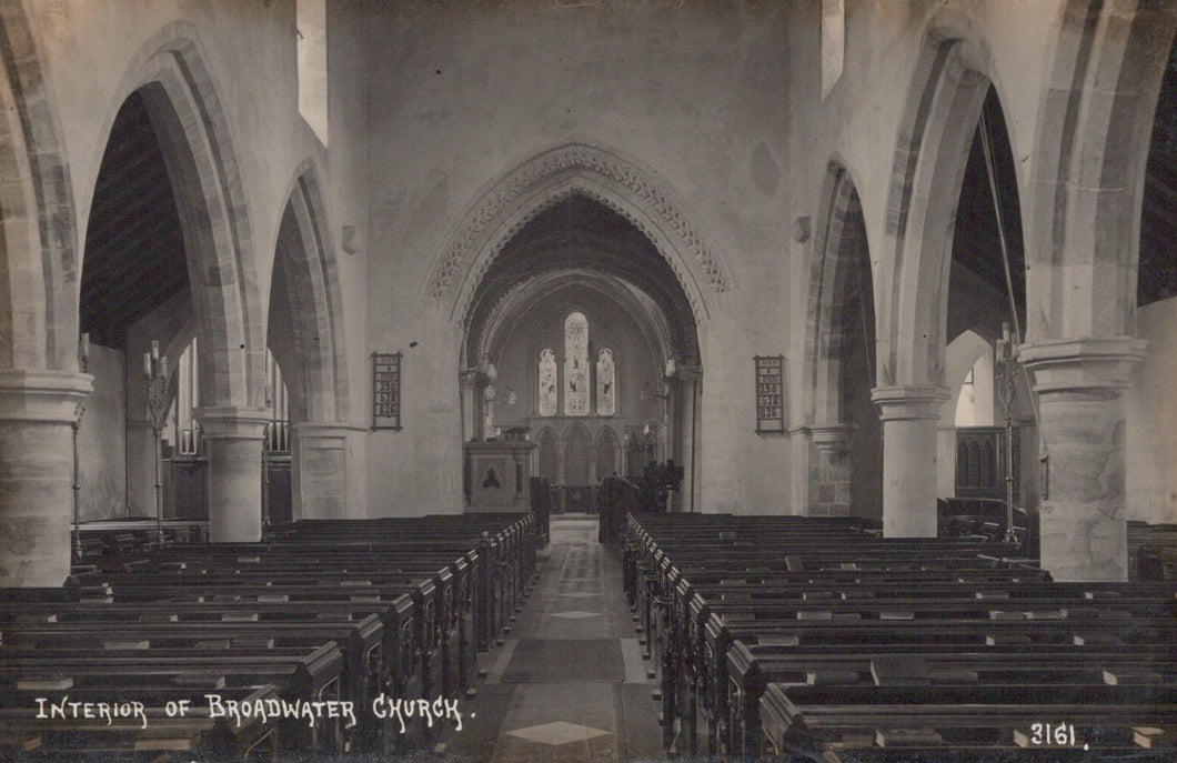 Interior of a church with pews and arches, vintage black and white photo.
