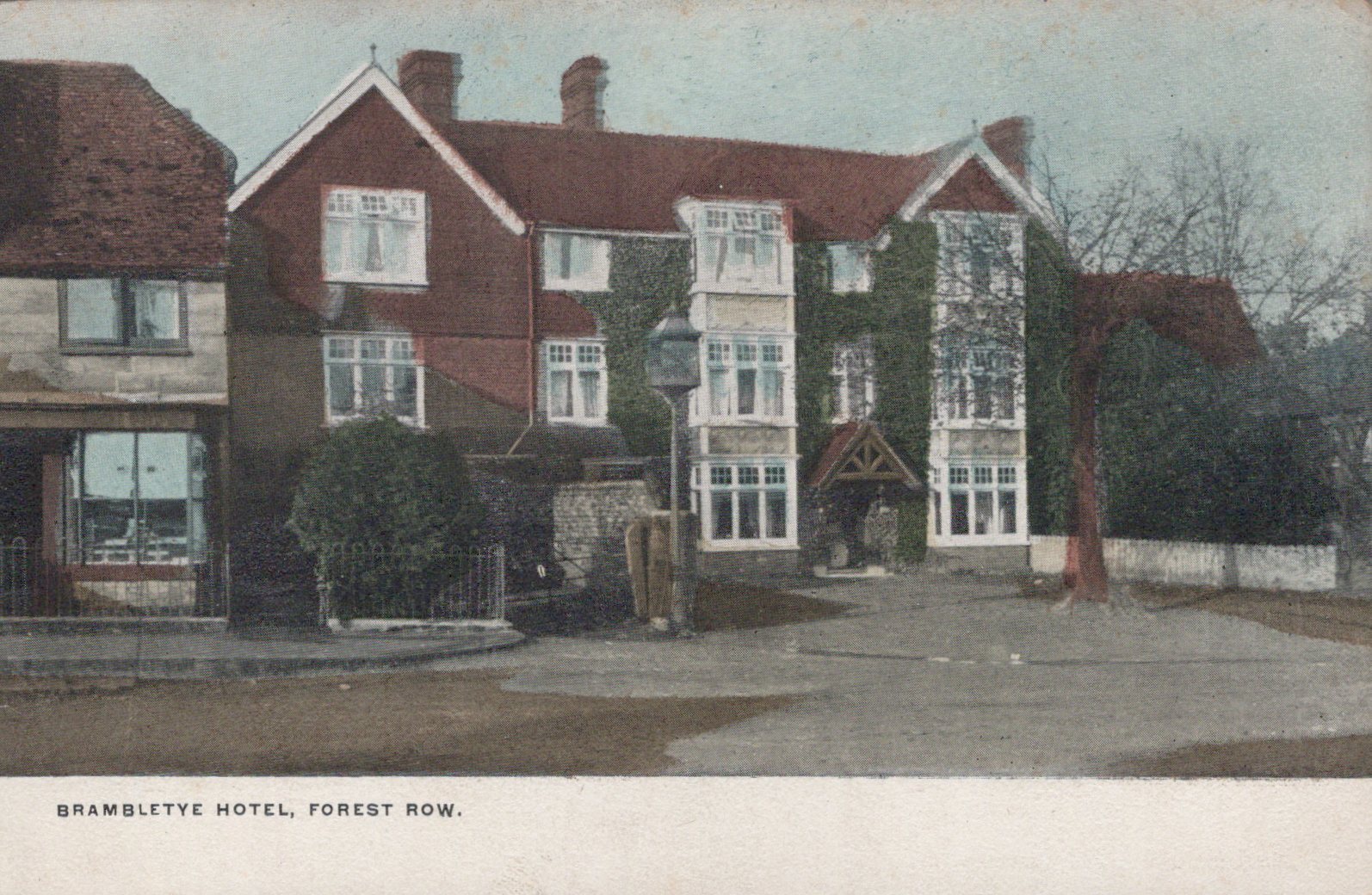Vintage postcard of Brambletye Hotel in Forest Row with a red roof and white walls.